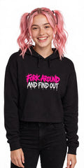 Woman with pink hair in pigtails wearing the Fork Around And Find Out crop hoodie with black jeans